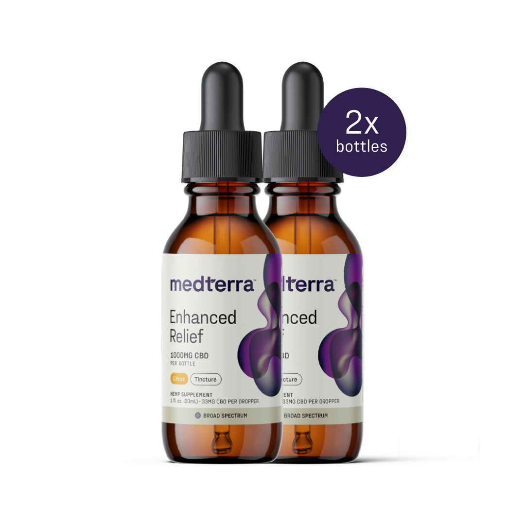 Two amber bottles with droppers labeled "Medterra Enhanced Relief Broad Spectrum CBD Oil" containing 1000mg of CBD each, stand side by side. A purple circle with text "2x bottles" is in the top right corner. The labels feature a purple abstract design and dosage information.